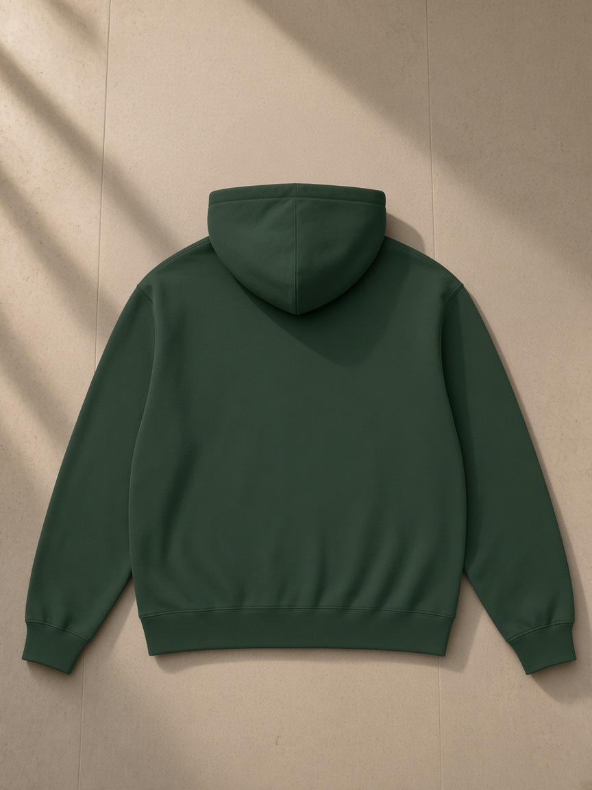 Women's heavyweight full-zip hoodie in Blackish Green, laid flat on pale limestone, back view