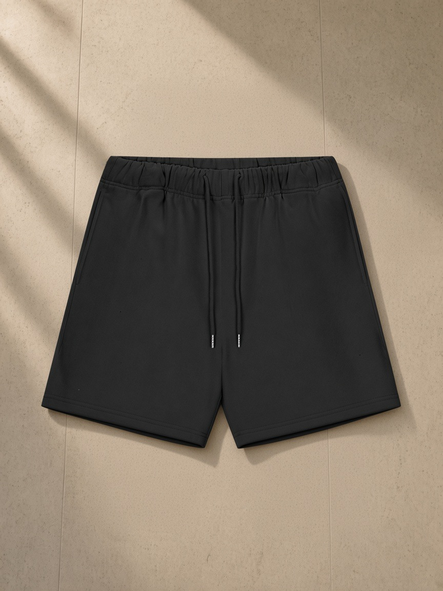 Heavyweight fleece loose fit shorts in Black Beauty, laid flat on pale limestone