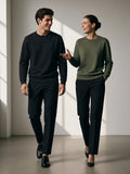 Two people in the Classic Cotton Sweatshirt in Classic Black and Olive Green in a low-key charcoal studio in the morning