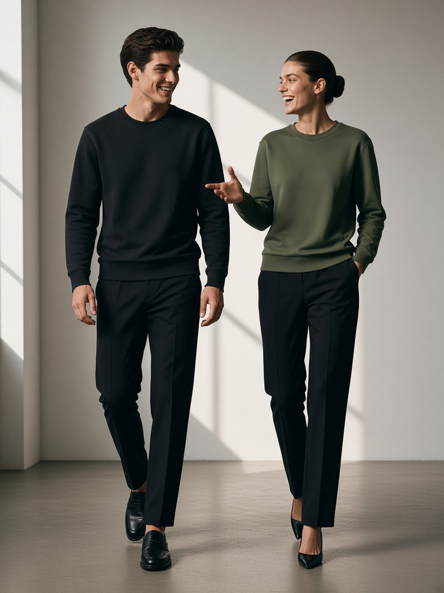 Two people in the Classic Cotton Sweatshirt in Classic Black and Olive Green in a low-key charcoal studio in the morning