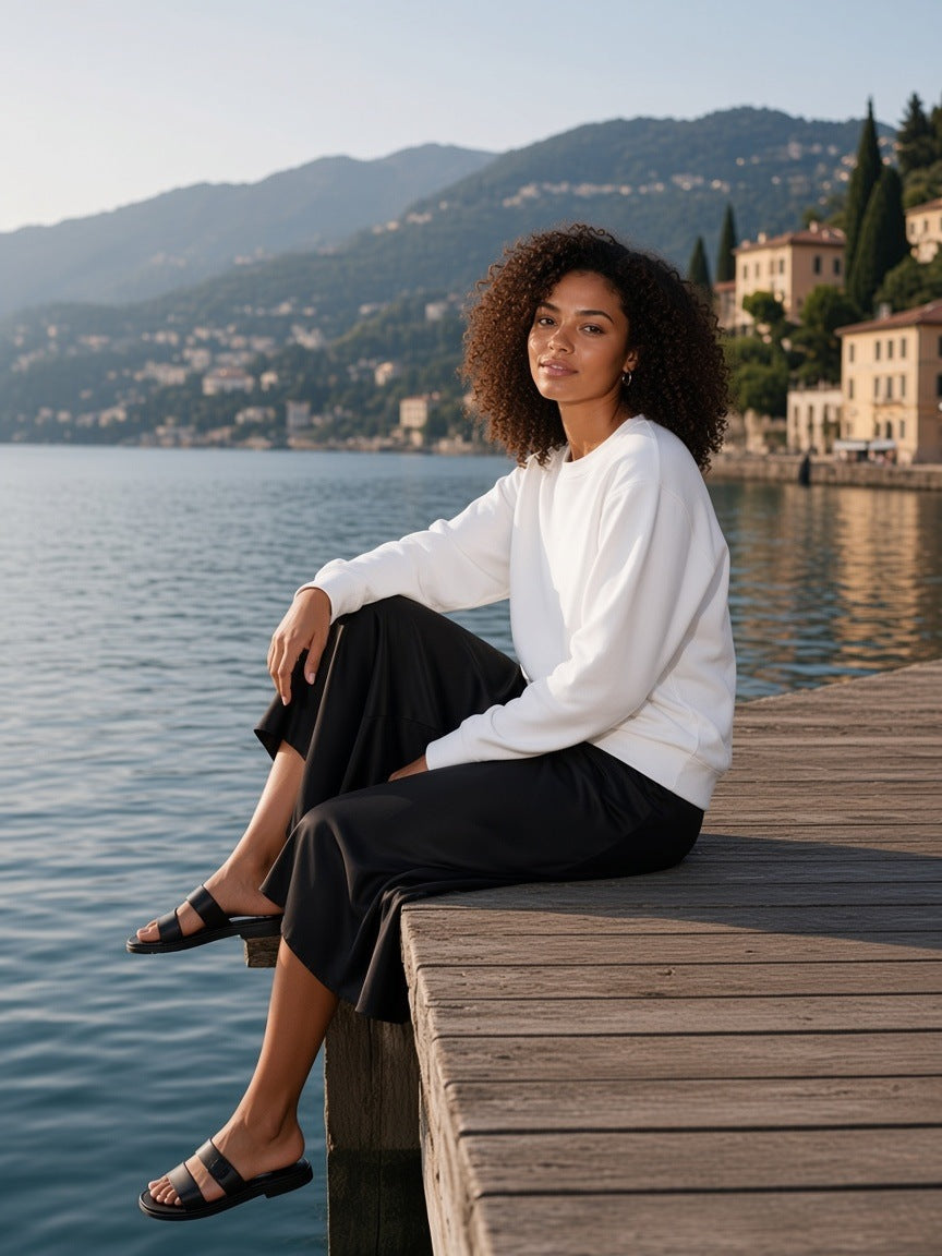 Woman in the Classic Cotton Sweatshirt in Lucent White standing on a Lake Como villa dock in the morning