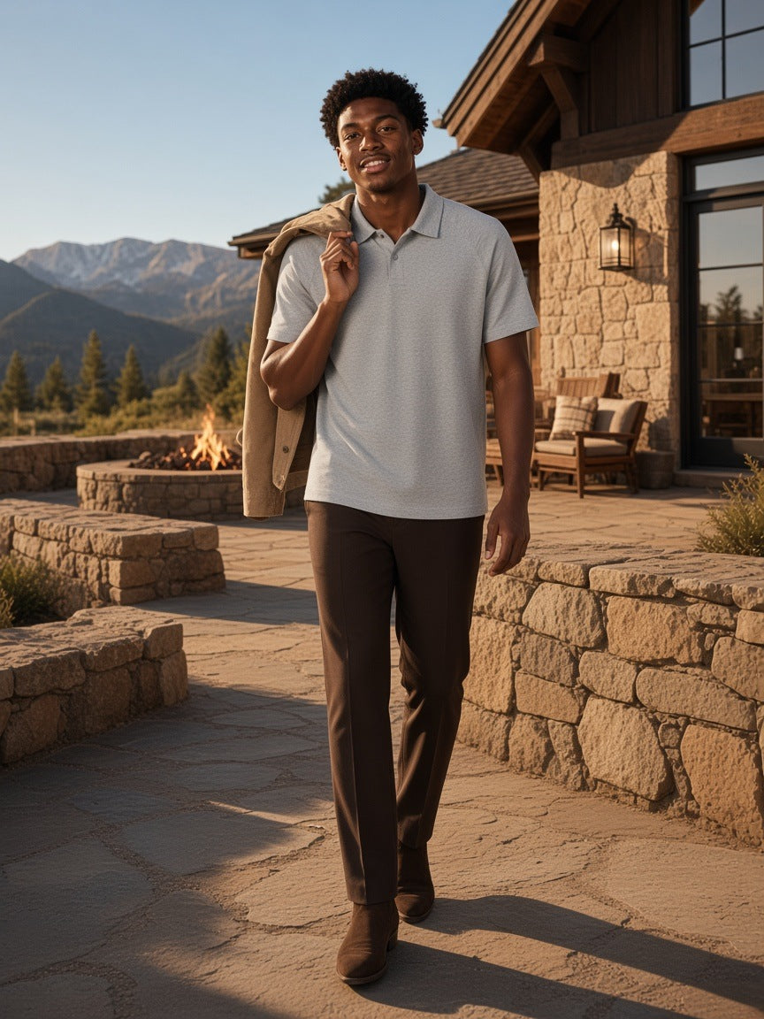 Man in the Classic Knit Polo in Flower Gray, jacket over his shoulder at a ranch lodge in Montana in the morning