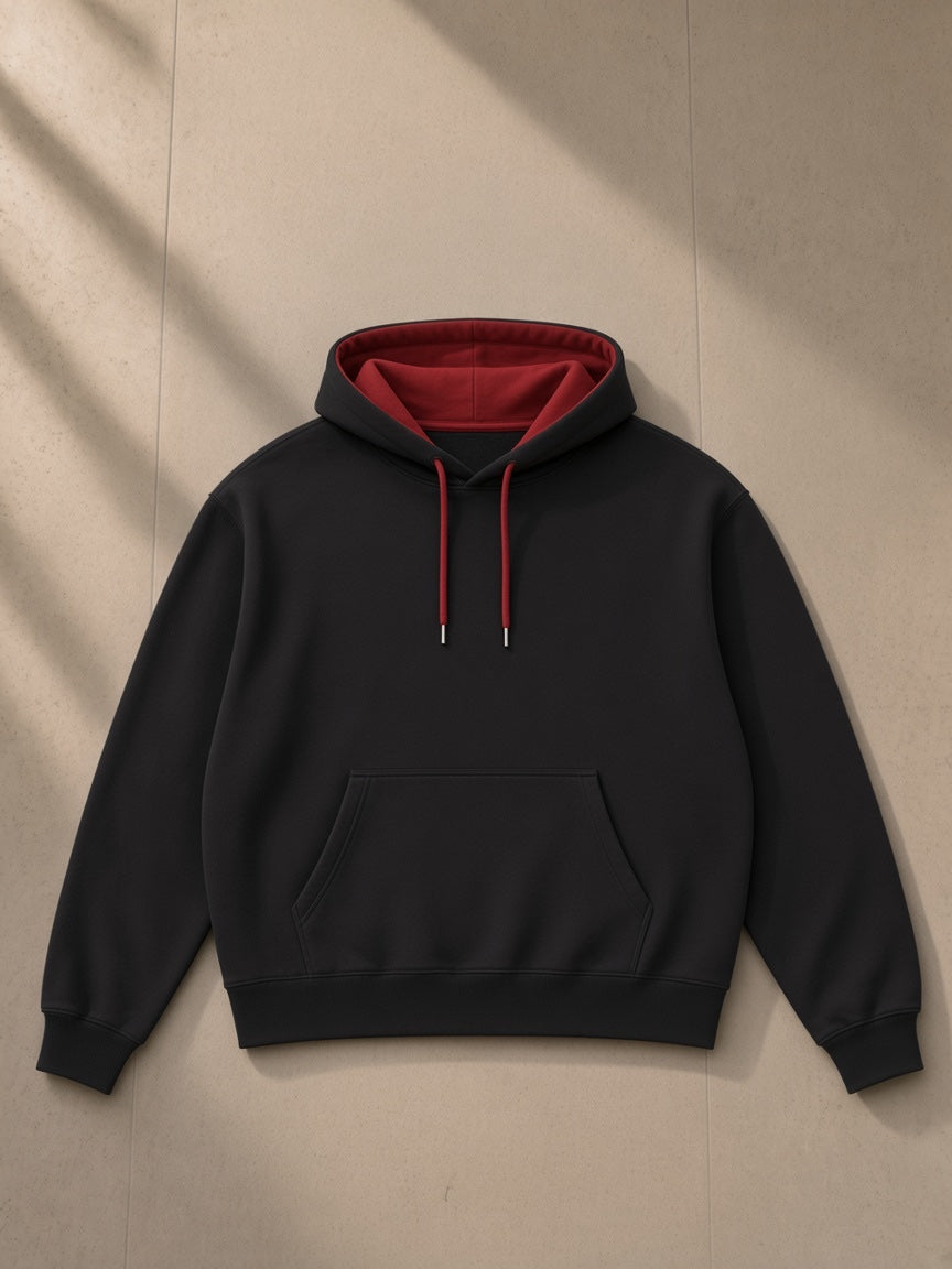 Contrast drawstring hoodie in Black, laid flat on pale limestone, front view