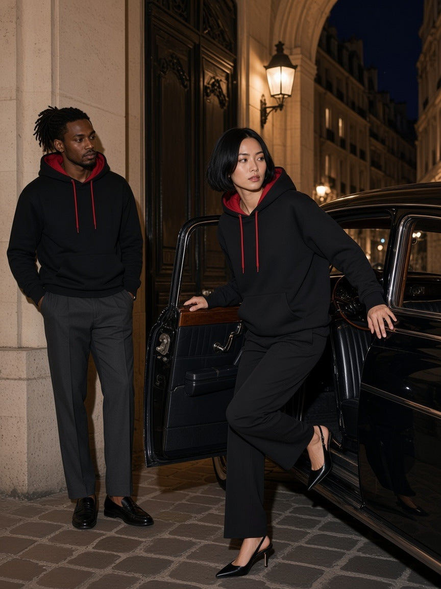 Two people in the Contrast Drawstring Hoodie in Black with red lining, a woman stepping out of a black car and a man leaning by a Paris porte-cochere at night