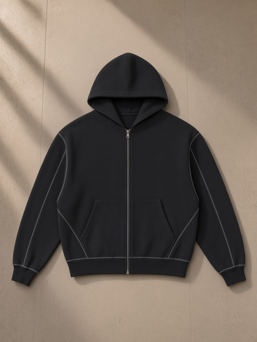 Contrast-stitched boxy fleece zip hoodie in Black, laid flat on pale limestone, front view