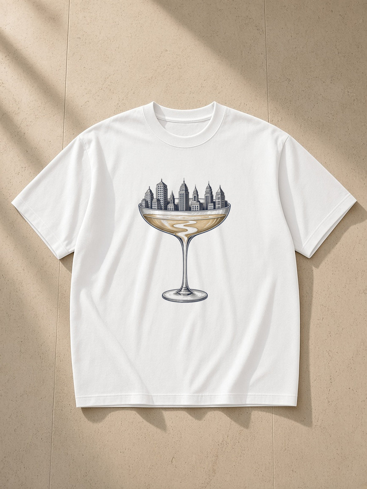 Coupe Over The City heavyweight drop-shoulder tee in White laid flat on pale limestone, the coupe engraving across the chest