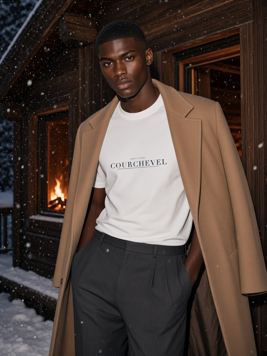 Man in the Courchevel Heavyweight Drop Shoulder T-Shirt in White at a snowy chalet door in Courchevel at night