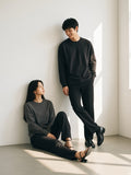 Two people in the Crew Neck Drop Shoulder Long Sleeve Shirt in Black and Dark Gray in a white plaster room by day