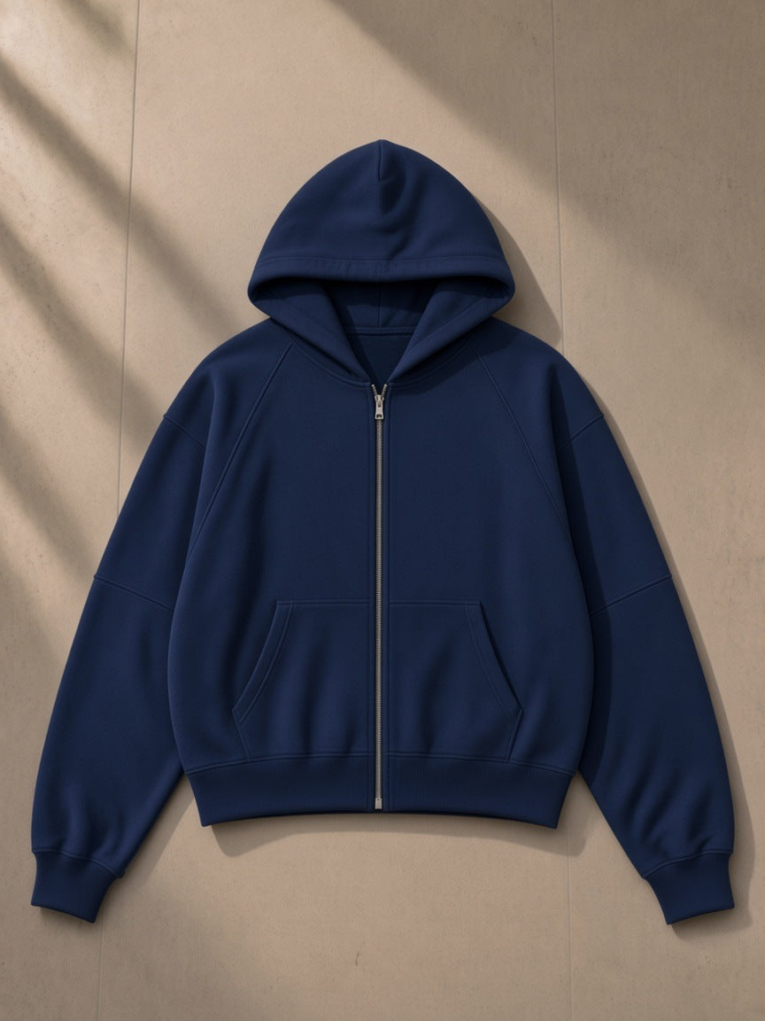 Cropped zip-through hoodie in Navy Blue, laid flat on pale limestone, front view