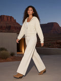 Woman in the Cropped Zip-Through Hoodie in Mild Apricot walking a desert resort courtyard in Utah at night