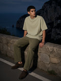 Man in the Mineral Wash Oversized T-Shirt in Apricot seated on a stone wall on the Via Krupp in Capri at night
