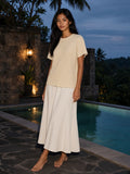 Woman in the Mineral Wash Waffle Knit T-Shirt in Light Apricot beside a villa pool in Bali at blue hour