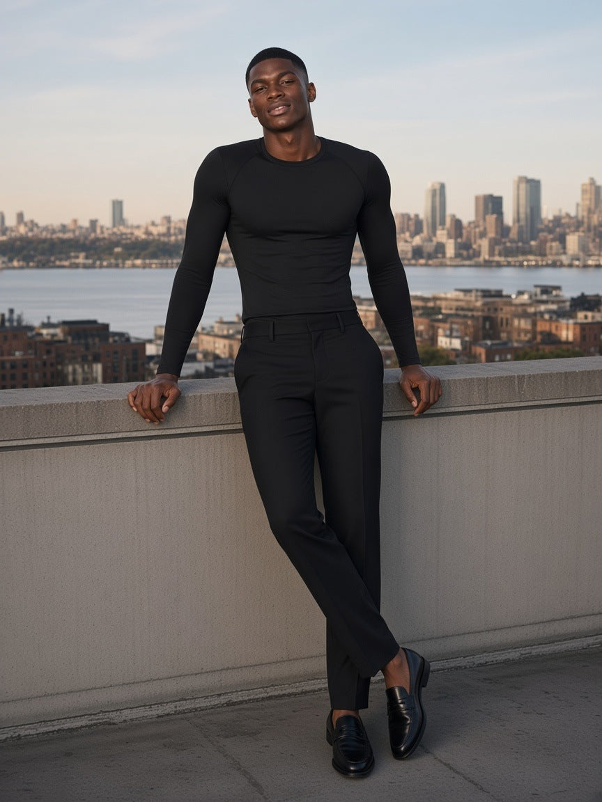 Man in the Performance Long Sleeve T-Shirt in Black standing on a rooftop over the Hudson in New York by day