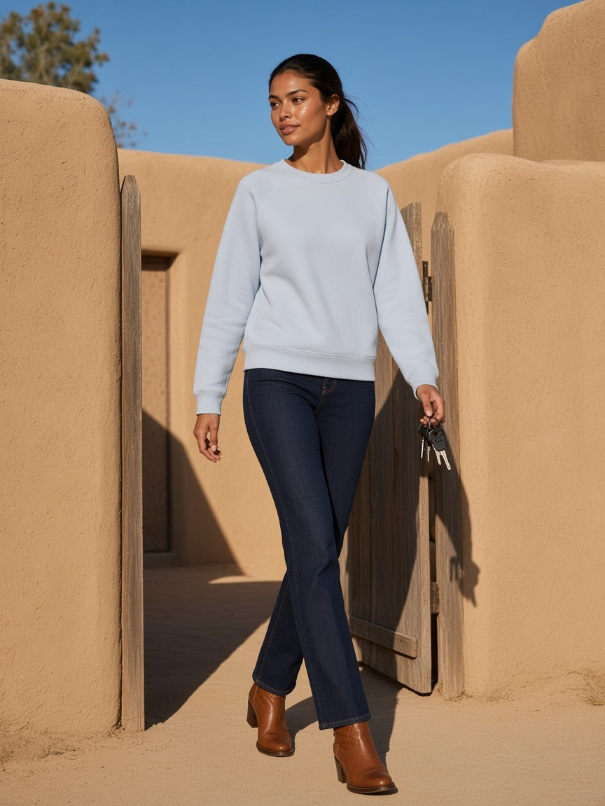 Woman in the Regular Fit Crewneck Sweatshirt in Light Blue in an adobe courtyard in Marfa, Texas in the morning
