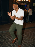 Man in the Regular Fit Polo Shirt in White with olive trousers and loafers, dancing outside a Harlem jazz club at 1am