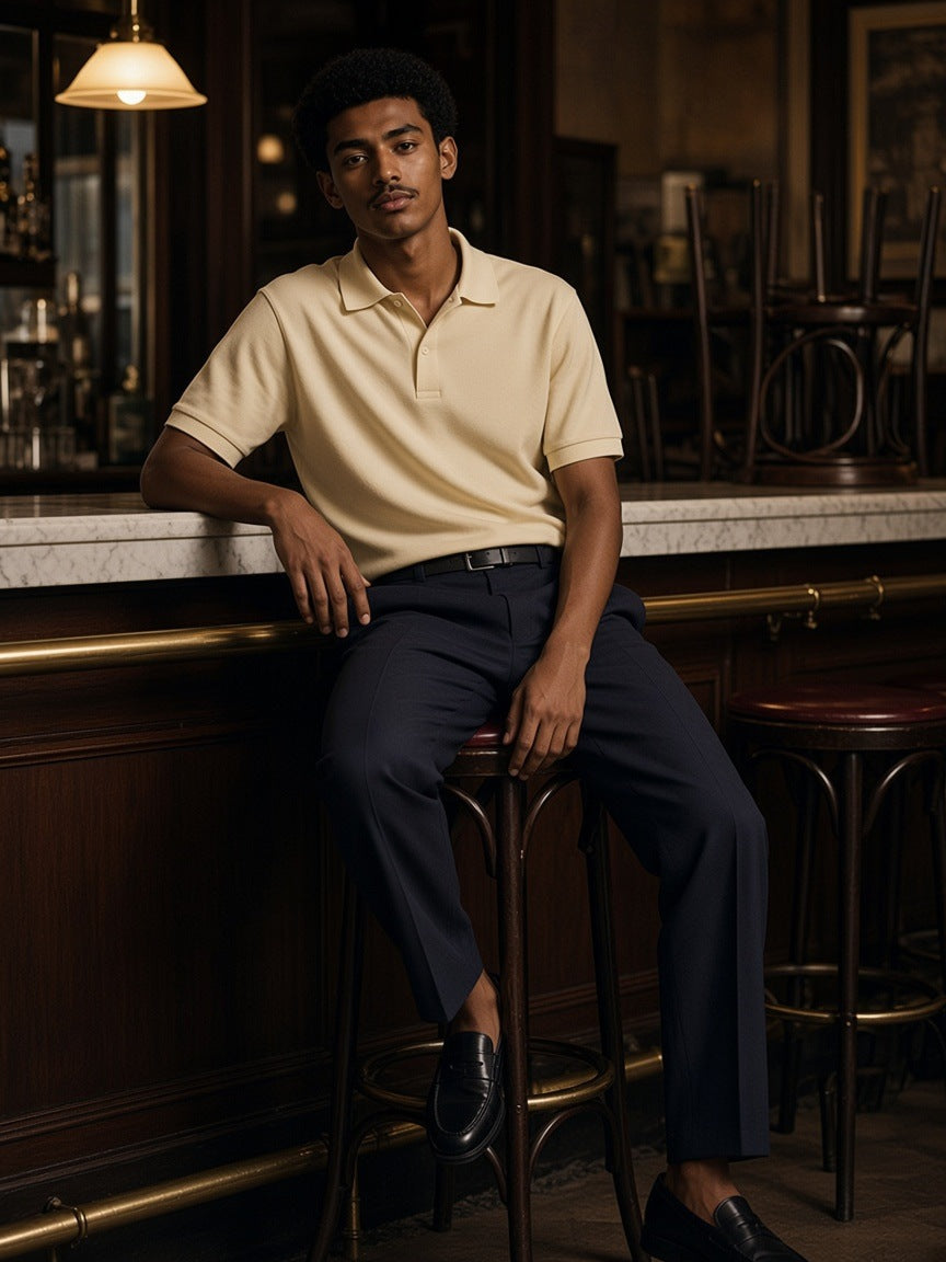 Man in the Regular Fit Polo Shirt in Apricot on a stool at a Viennese café counter at closing time