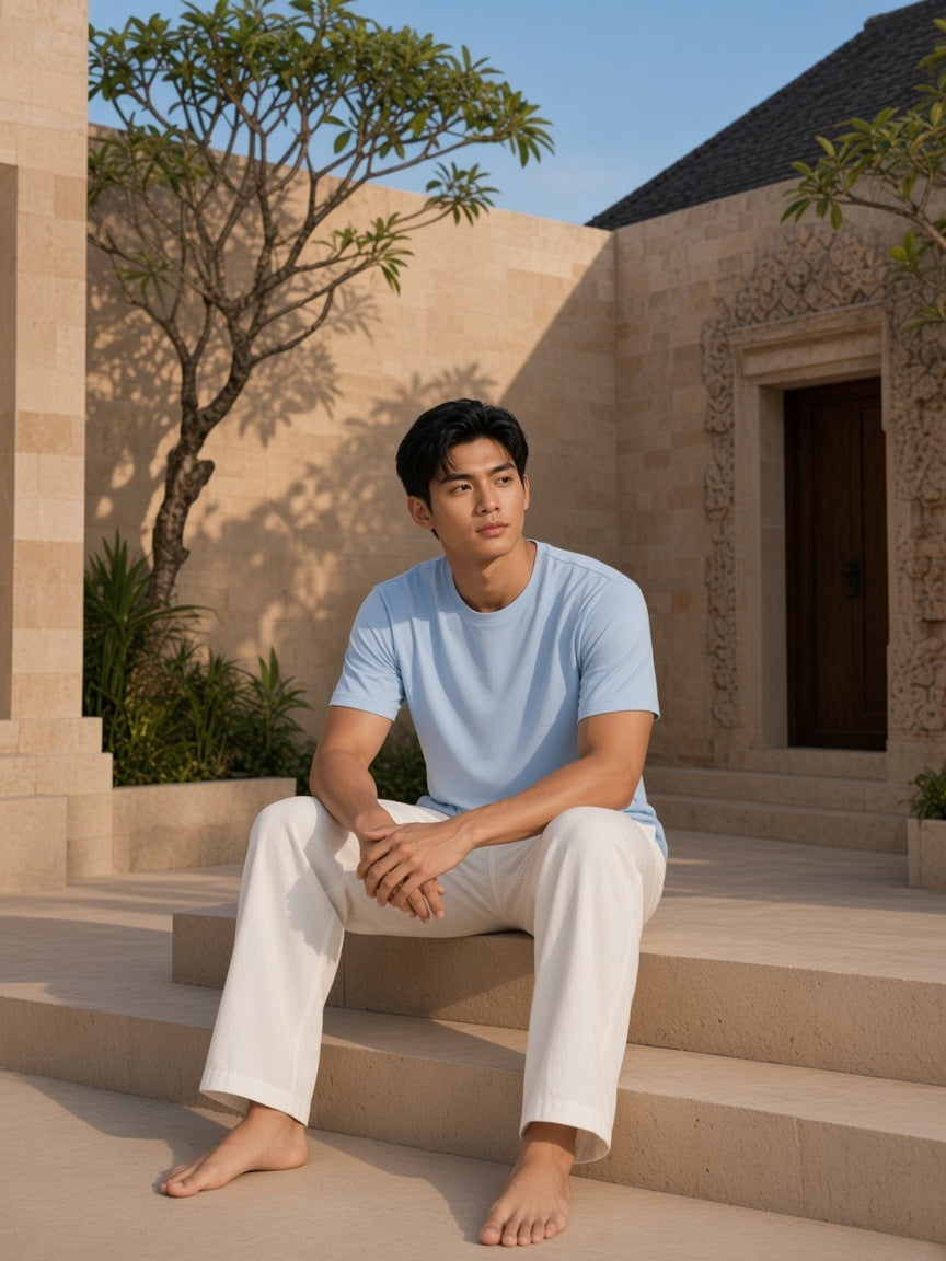 Man in the Sunfade T-Shirt in Sky Blue in a stone resort courtyard in Ubud, Bali in the morning