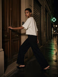 Woman in the Vintage Wash Boxy T-Shirt in White pushing open a door on Rue Saint-Denis in Paris at night