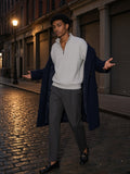 Man in the Vintage Wash Fleece Quarter Zip Sweatshirt in Flower Gray with charcoal pleated trousers and a navy overcoat, on Mercer Street cobbles in SoHo at night