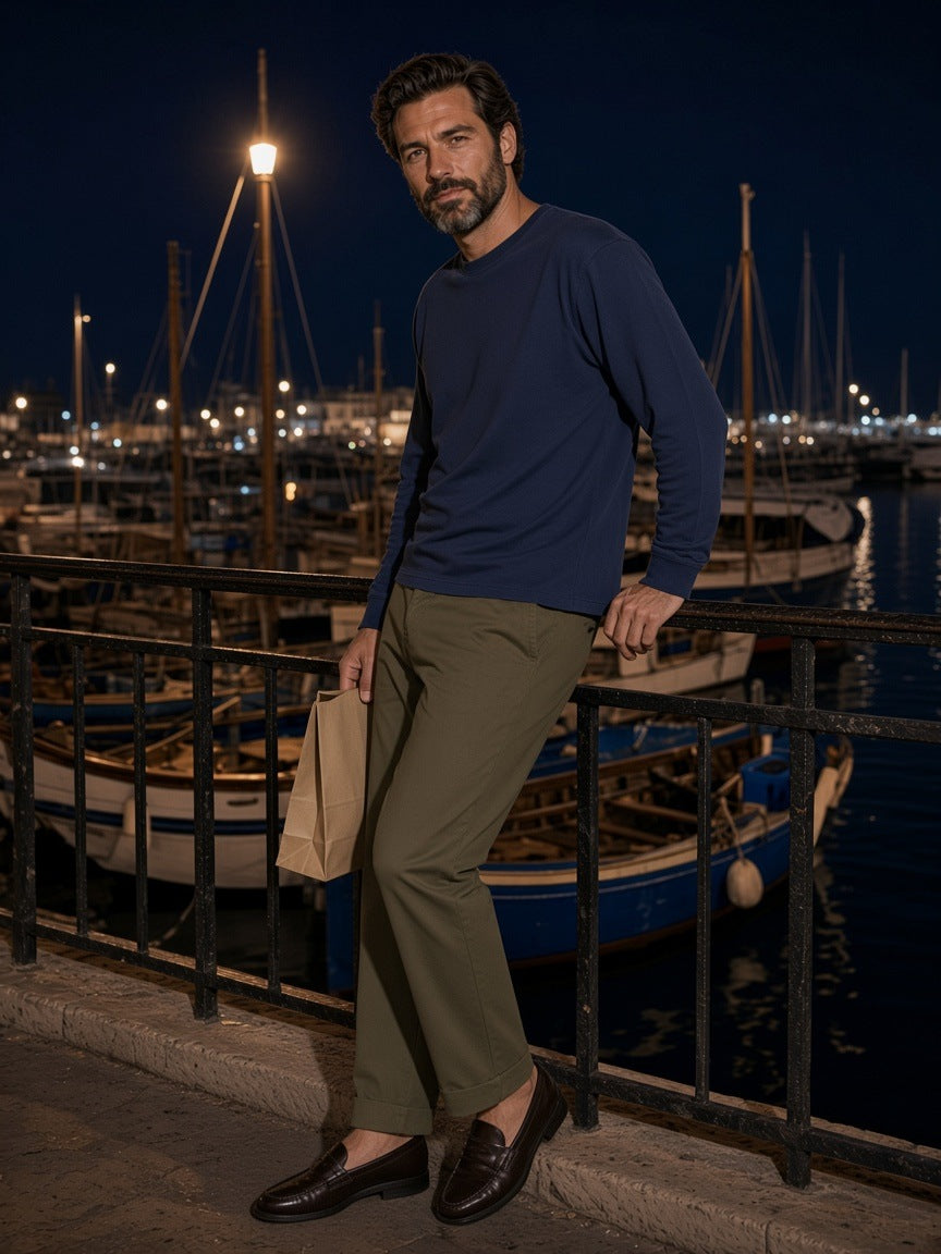 Man in the Vintage Wash Long Sleeve Boxy T-Shirt in Navy Blue at a railing on the Old Port quay in Marseille at night
