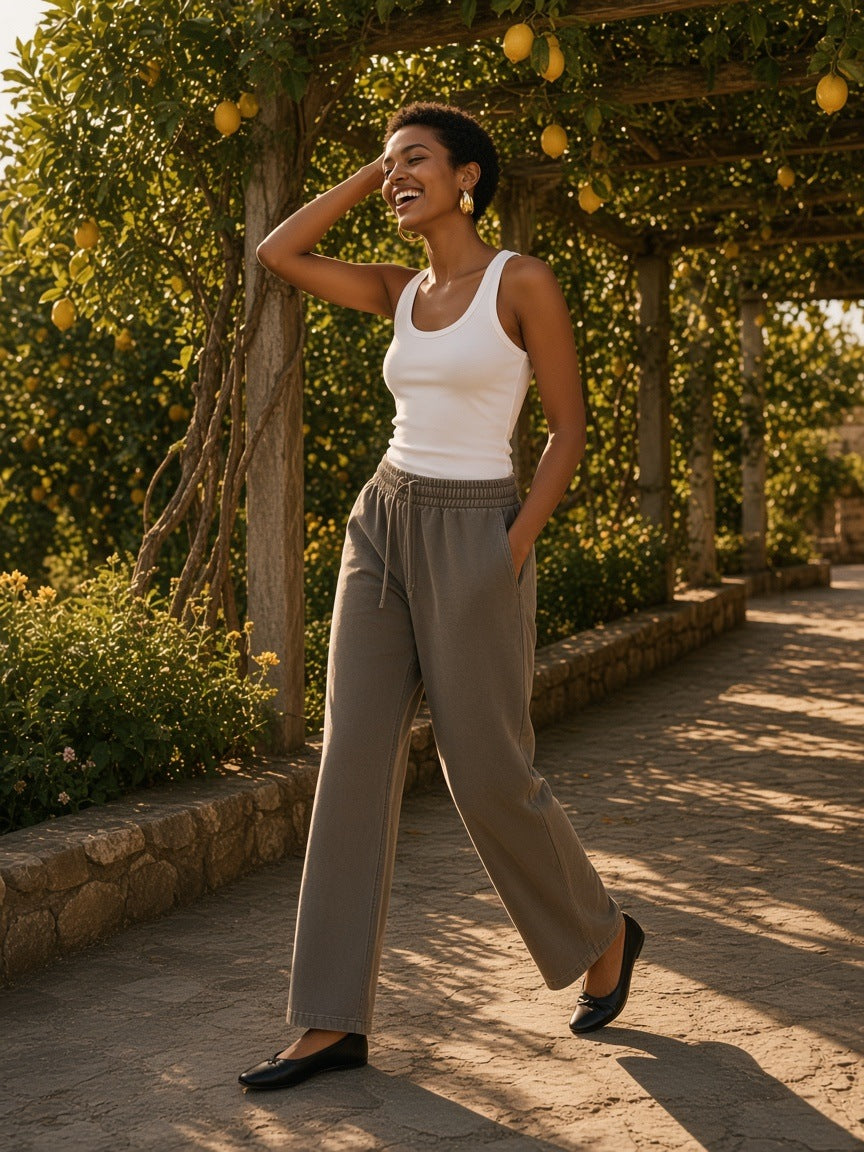 Woman in the Vintage Washed Waist Pants in Coffee laughing on a lemon-grove path on the Amalfi Coast at golden hour