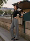 Woman in the Vintage Washed Waist Pants in Medium Gray lowering the lid of a riverside bookstall on a Seine quay in Paris at blue hour