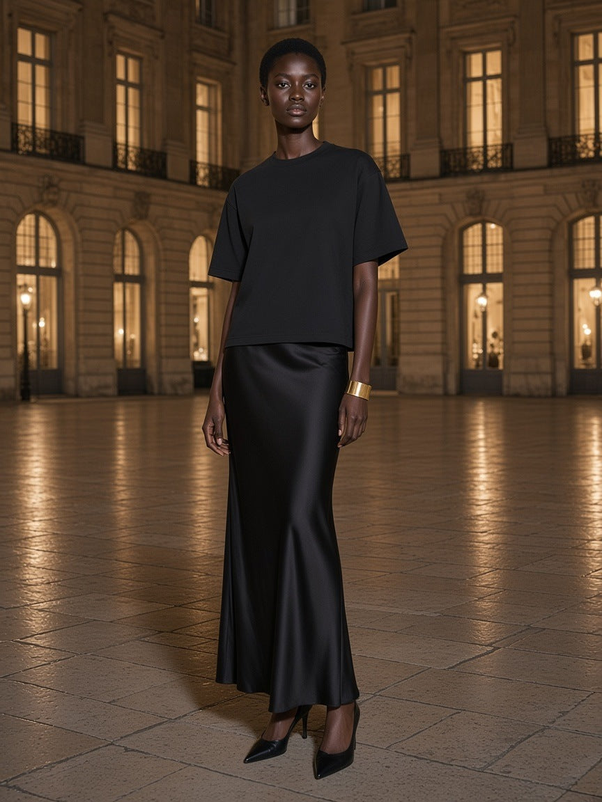 Woman in the Marcel Afters Washed Rolled Hem Half Sleeve T-Shirt in Black, in a grand hotel's limestone courtyard at night in Paris
