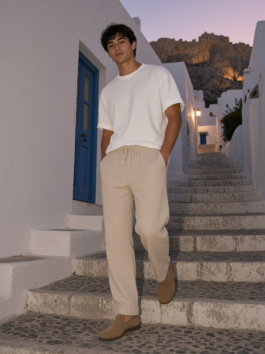 Man in the Marcel Afters Washed Rolled Hem Half Sleeve T-Shirt in White on a whitewashed hotel stair on Mykonos at dusk