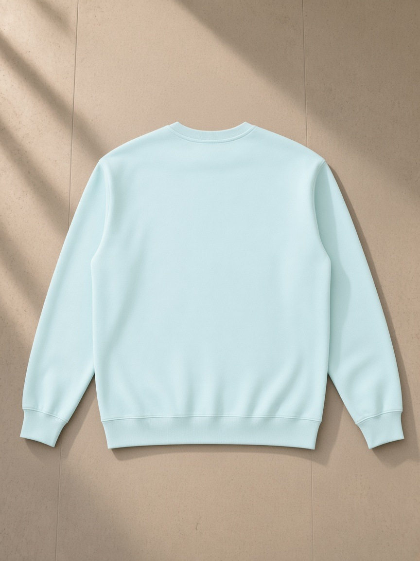 Essential heavyweight crewneck sweatshirt in Water Blue, laid flat on pale limestone, back view
