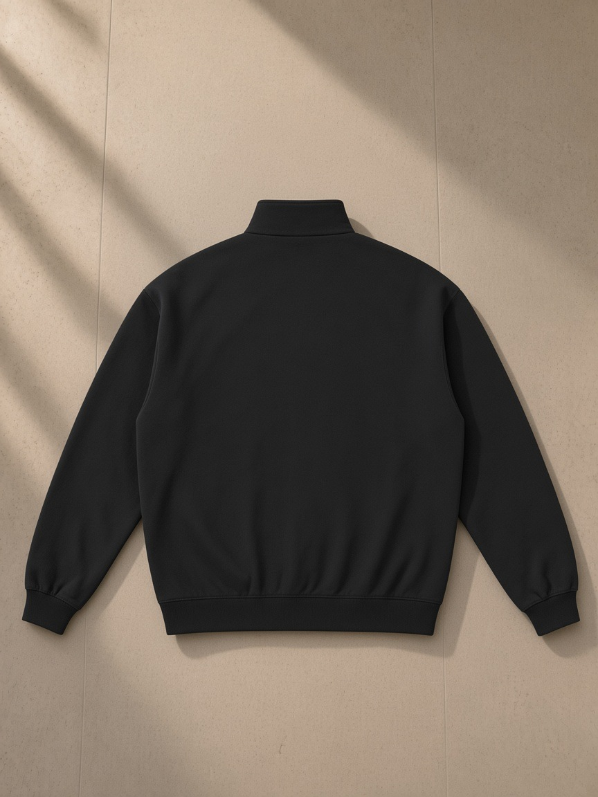 Essential Heavyweight Stand Collar Jacket in Black, laid flat on pale limestone, back view