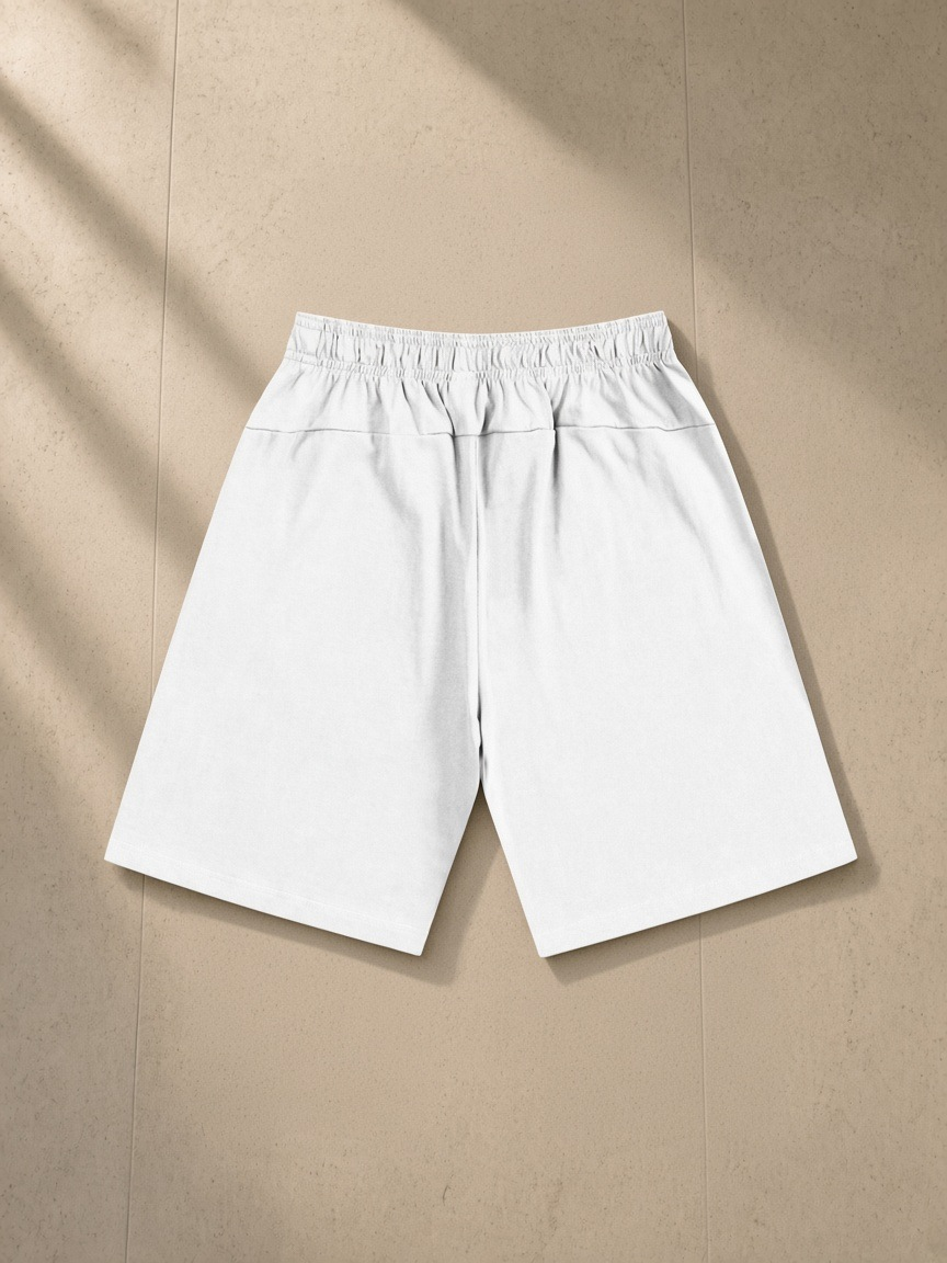 Essential Heavyweight Cotton Shorts in White, laid flat on pale limestone, back.