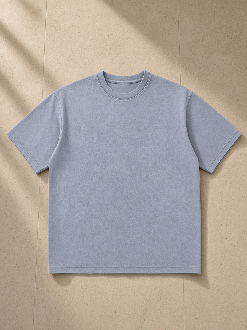 Unisex bamboo slub snow washed t-shirt in Lake Ice Blue, laid flat on pale limestone