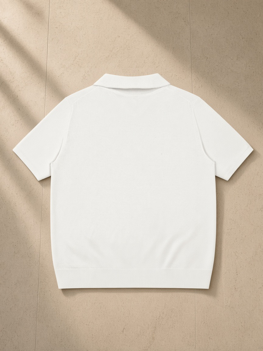 Heavyweight Oversized Polo in White, laid flat on pale limestone, back view