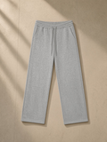 Unisex heavyweight sweatpants in Flower Gray, laid flat on pale limestone