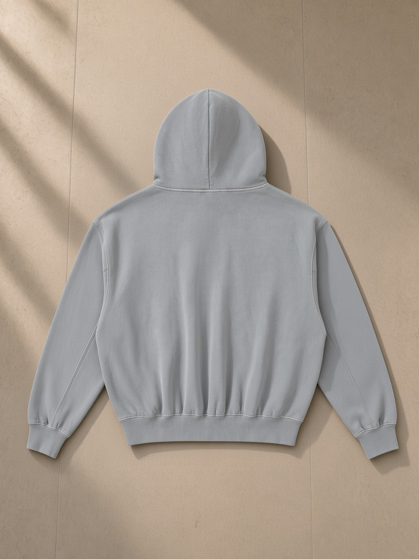 Frayed Enzyme Washed Fleece Hoodie in Light Gray, laid flat on pale limestone, back view
