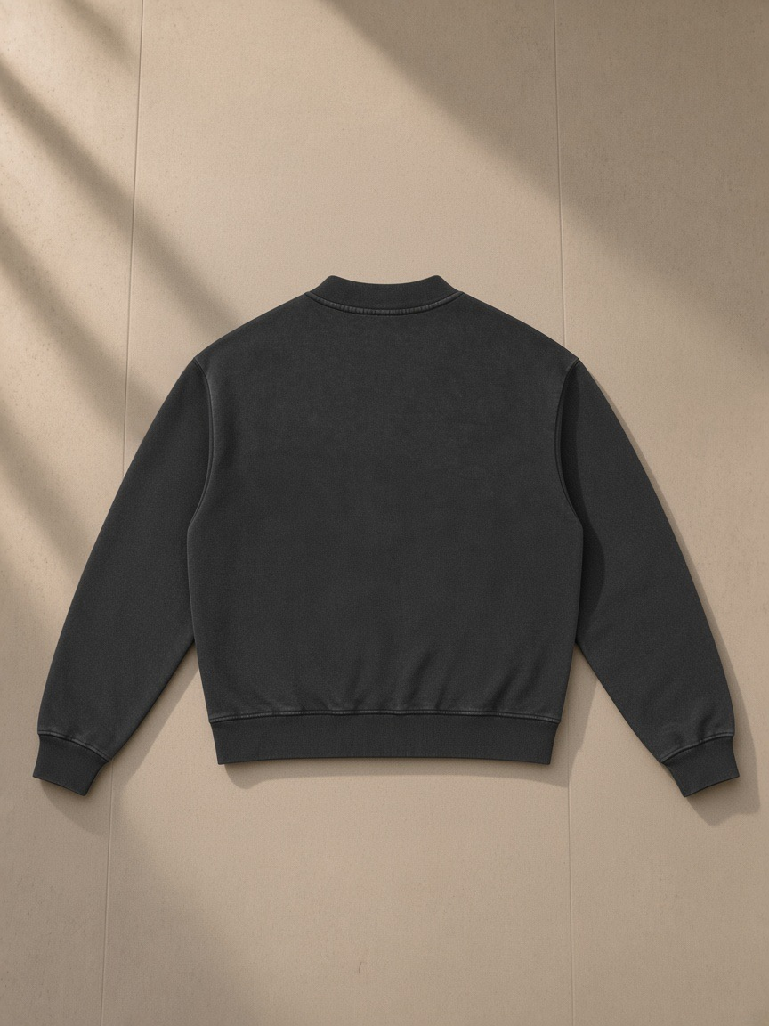 Unisex vintage wash fleece quarter zip sweatshirt in Black, laid flat on pale limestone, back view