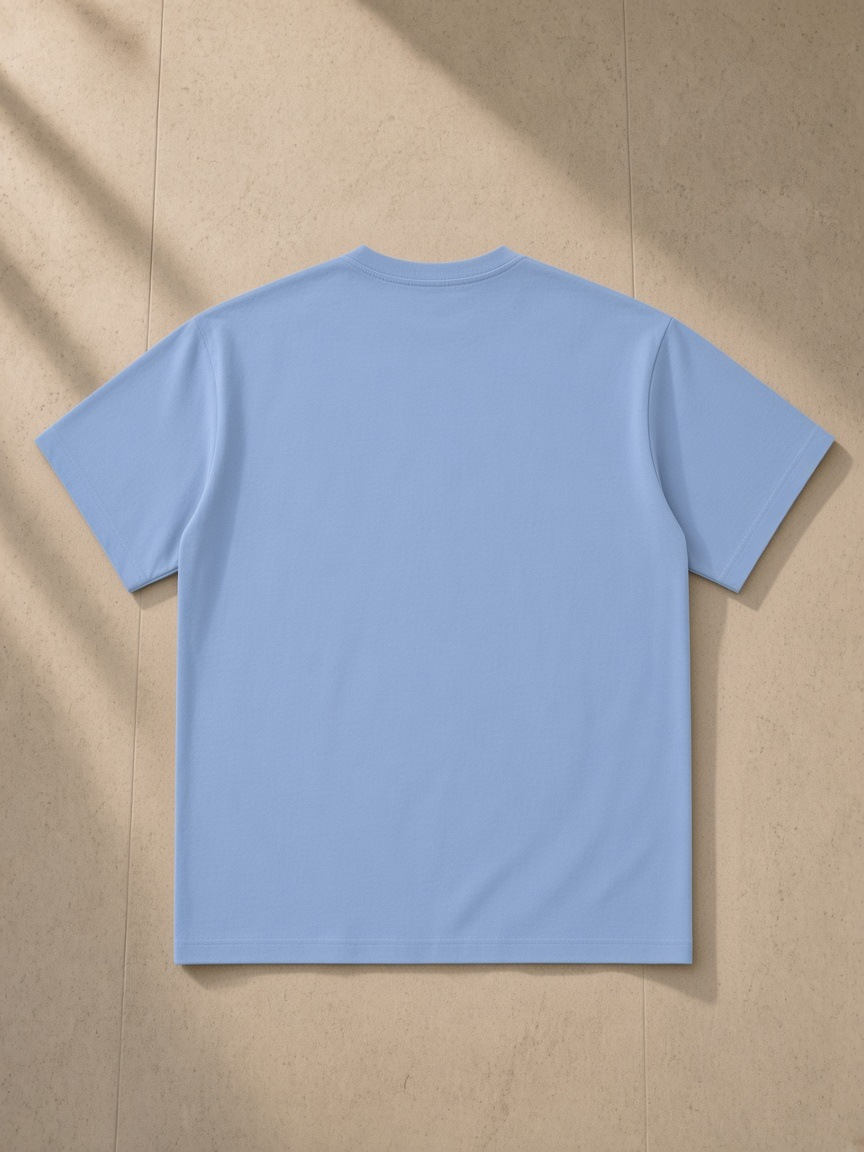 Sueded Cotton T-Shirt in Light Blue, laid flat on pale limestone, back.