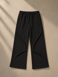 Wide Leg Drawstring Sweatpants in Black, laid flat on pale limestone