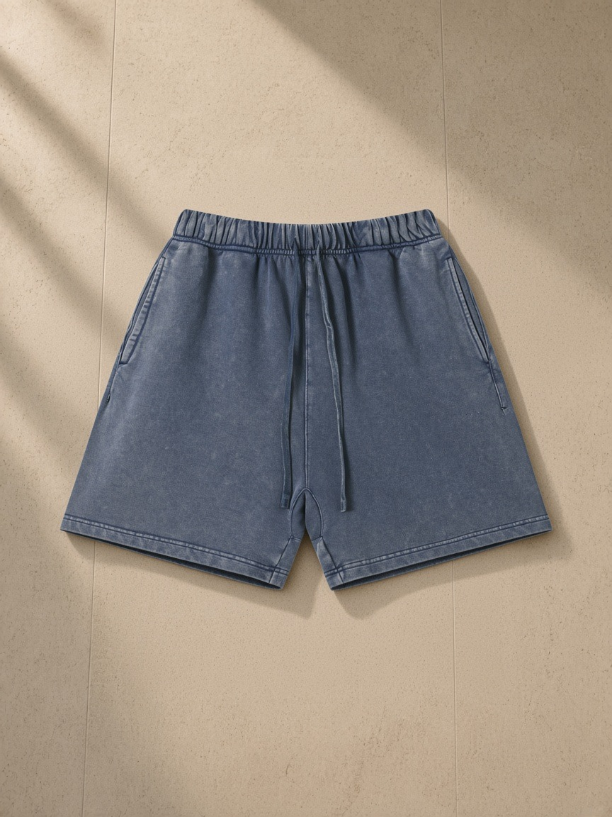 Vintage Wash Cotton Shorts in Navy Blue, laid flat on pale limestone