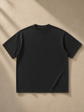Women's heavyweight vintage washed frayed t-shirt in Black, laid flat on pale limestone