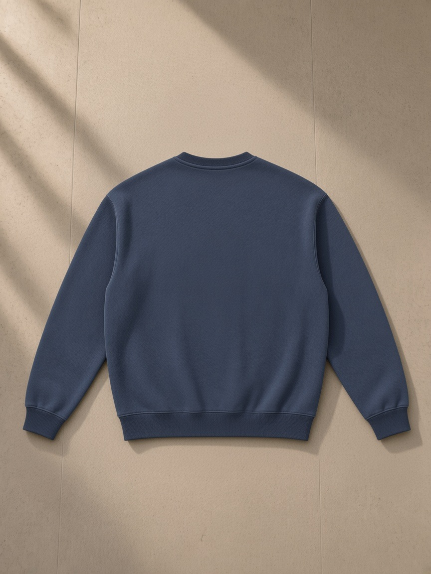Fleeced sweatshirt in Navy Blue, laid flat on pale limestone, back view