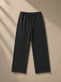 Snow Washed Raw Edge Sweatpants in Black, laid flat on pale limestone