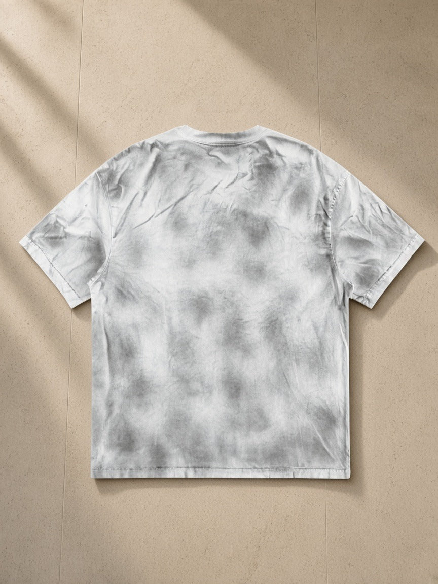 Dirty Washed Loose T-Shirt in Washed White, laid flat on pale limestone, back view