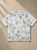 Dirty Washed Loose T-Shirt in Washed White, laid flat on pale limestone