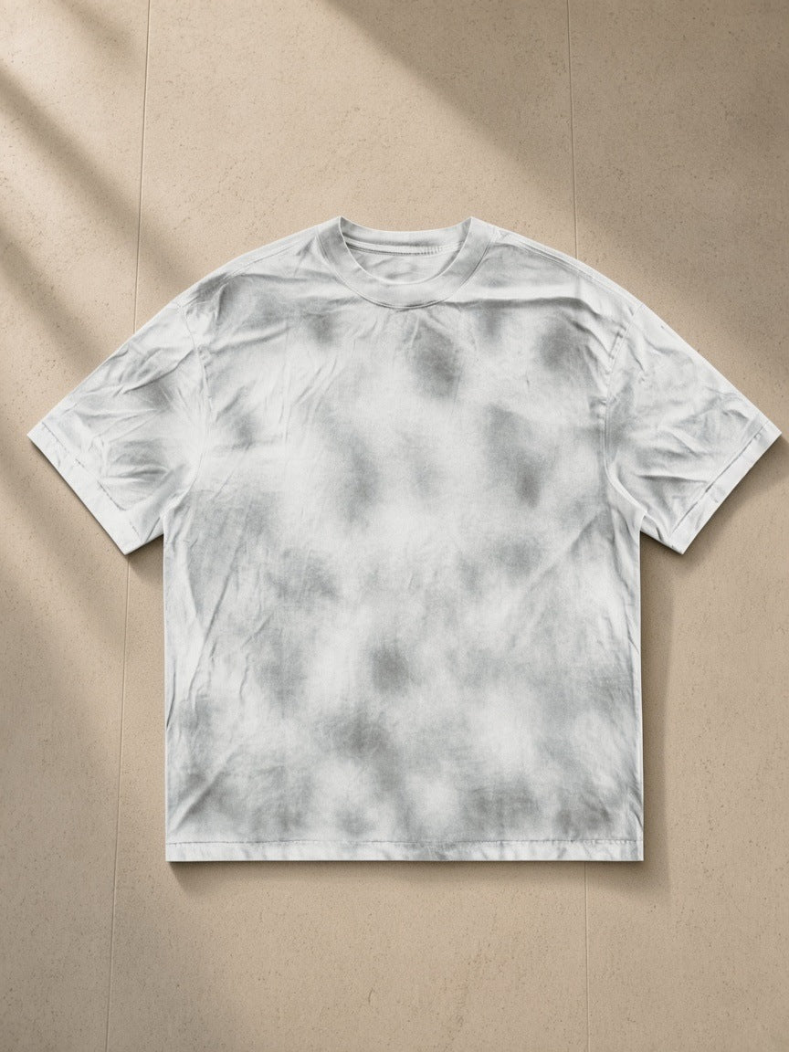 Dirty Washed Loose T-Shirt in Washed White, laid flat on pale limestone
