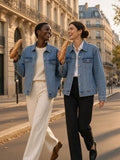 Two women in the Vintage Wash Denim Jacket in Blue, arm in arm on a Paris street at golden hour