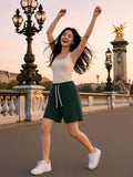 Woman in the Drawstring Shorts in Dark Green twirling on the Pont Alexandre III at sunset