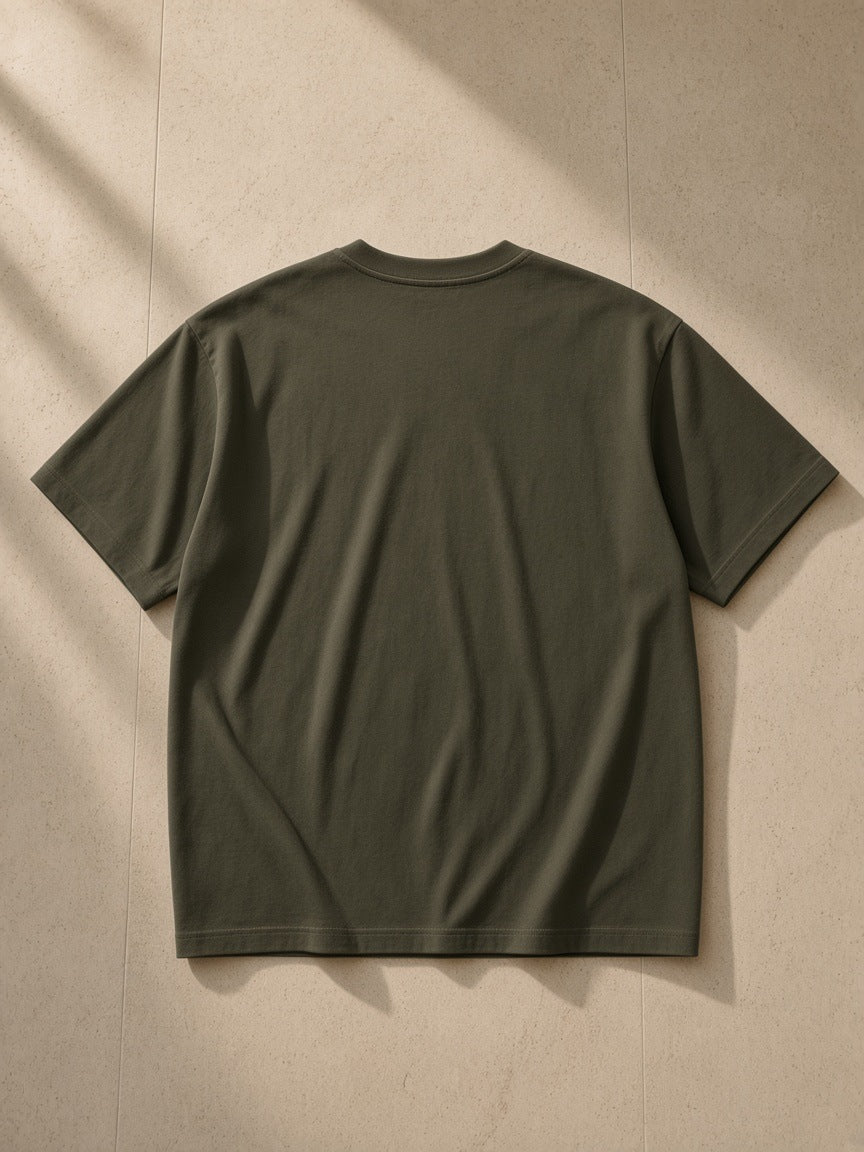 Drop Shoulder Cotton T-Shirt in Army Green, laid flat on pale limestone, back view