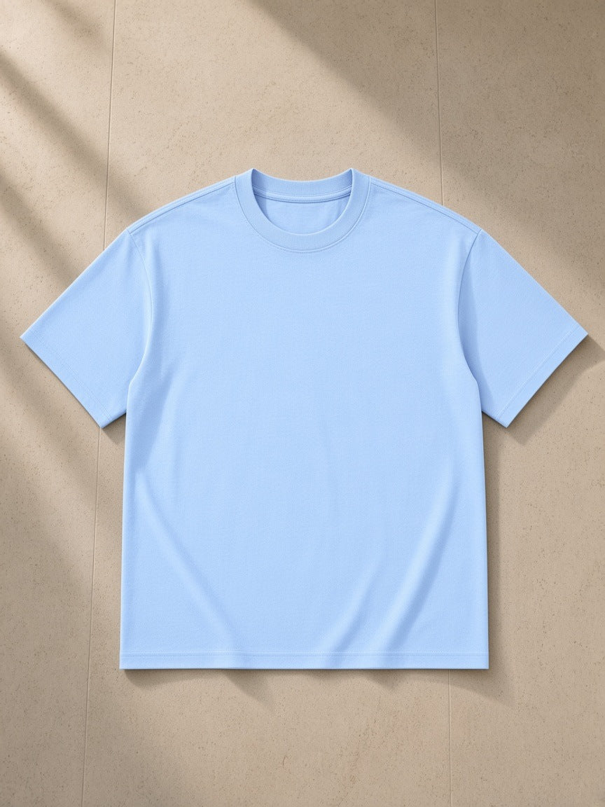 Drop Shoulder Cotton T-Shirt in Blue, laid flat on pale limestone