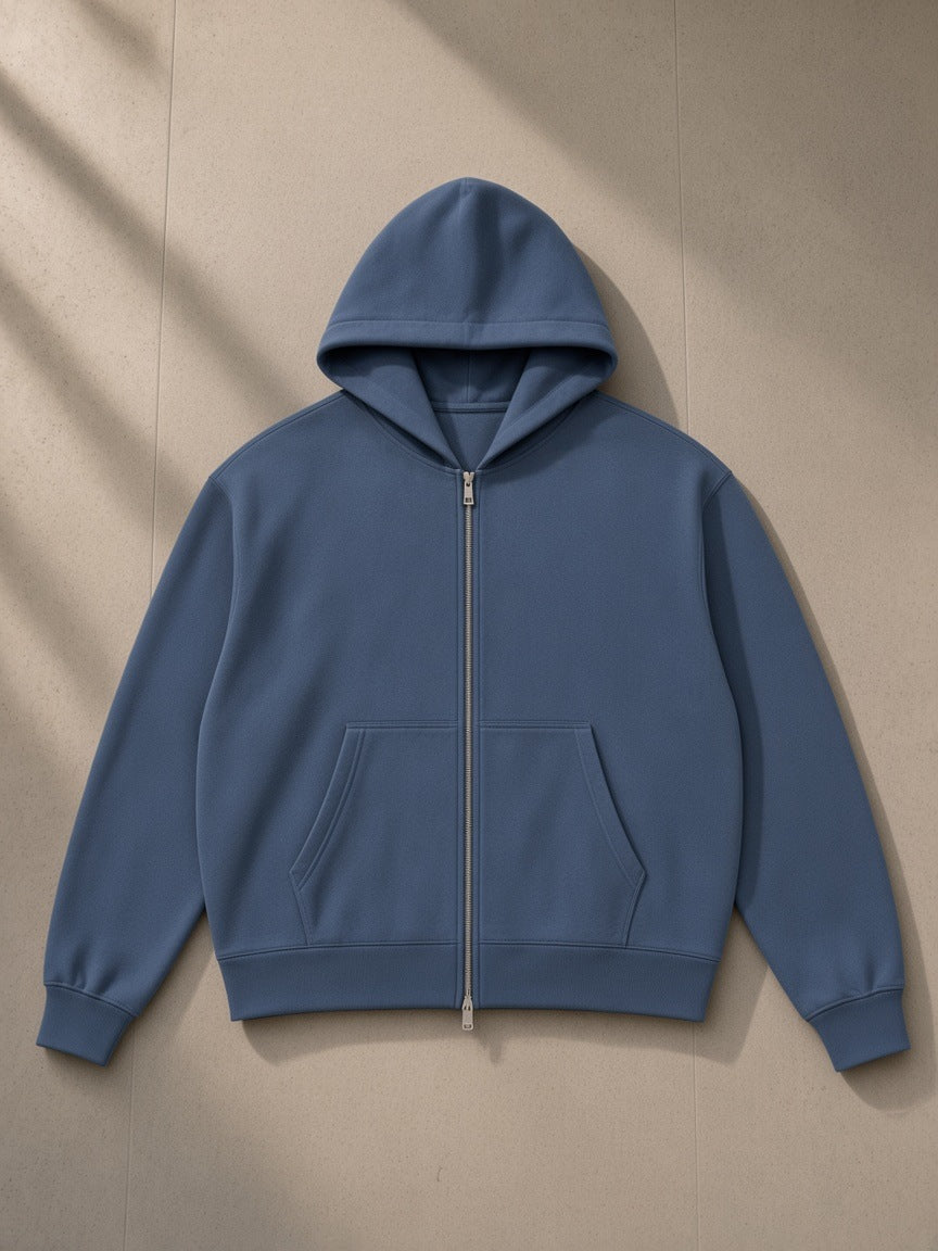 Drop Shoulder Full Zip Hoodie in Haze Blue, laid flat on pale limestone